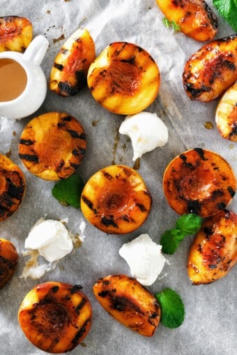 grilled peaches with ice cream and mint leaves