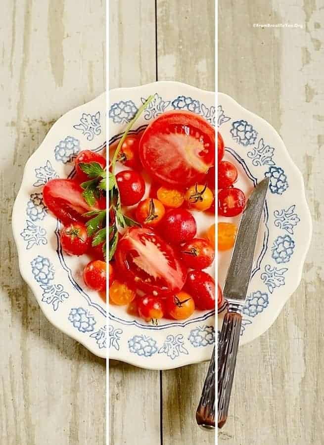 A blue and white patterned plate with red and orange cherry tomatoes and larger red tomato slices.