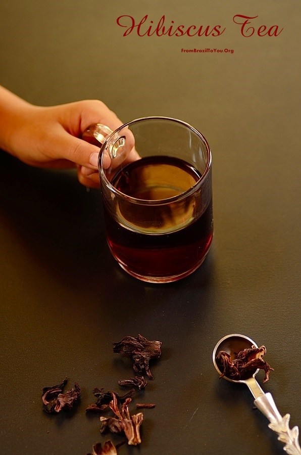a glass of tea is held in the fingers of one hand