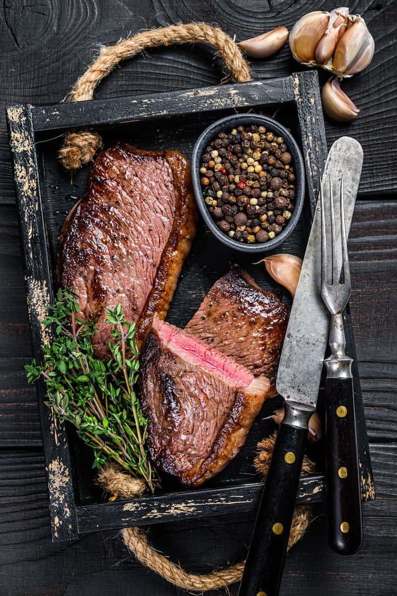 picanha assada inteira em uma bandeija de madeira 