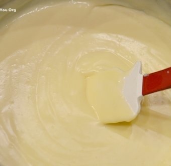 spatula stirring a bowl of yellow custard cream