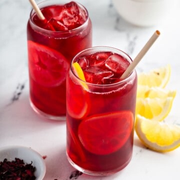 Iced hibiscus tea with lemon slices in glasses.