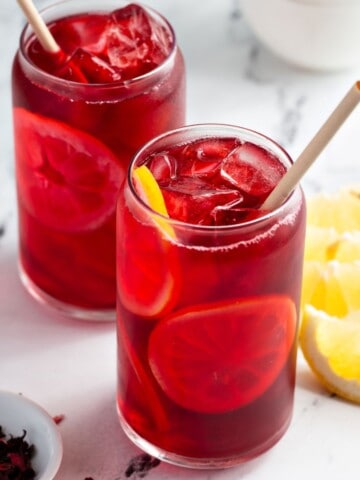 Iced hibiscus tea with lemon slices in glasses.