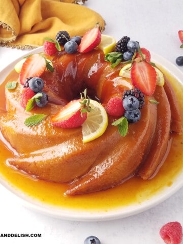 close up do pudim de pão inteiro e decorado com calda de caramelo e frutas