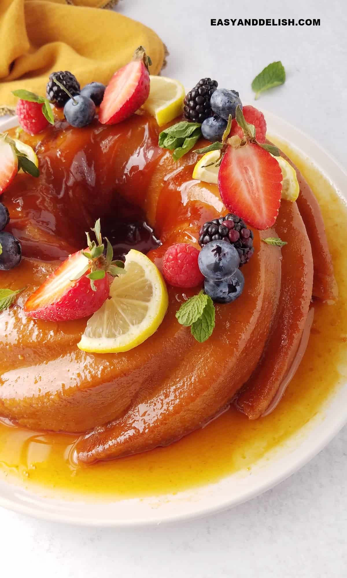 metade de um pudim de pão decorado com frutas por cima.