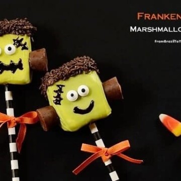 Two marshmallow candy pops decorated to like like Frankenstein's monster and tied with orange ribbons