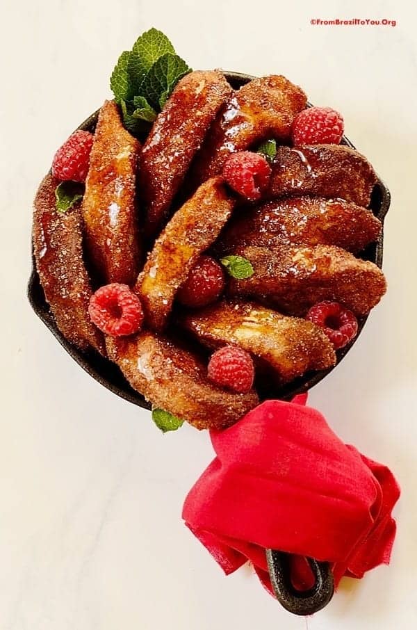 Brazilian French toast garnished with berries in a skillet