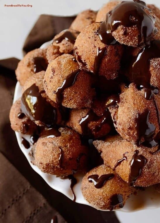 A list of 50 easy Brazilian recipes to must try including healthy and indulgent dishes that will make your mouth water. All ingredients are available in local supermarkets. Chocolate truffle filled doughnut holes on a pile