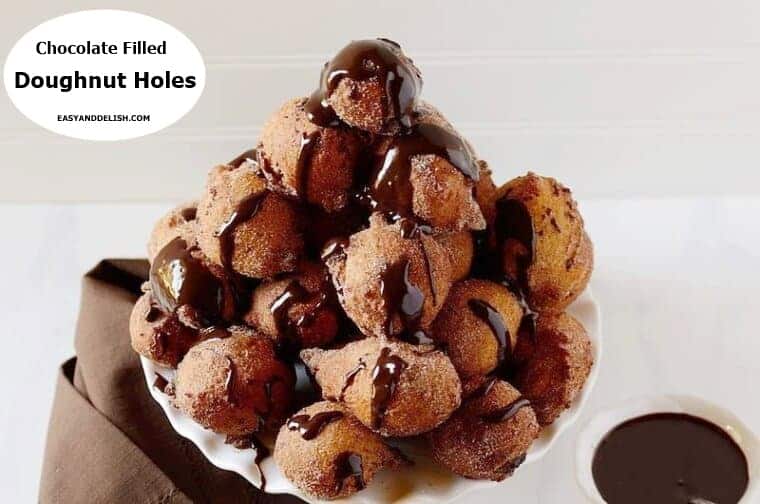 Chocolate filled doughnut holes with a bowl of chocolate sauce on the side.