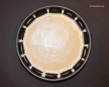Layering ice cream filling in a round pan for dutch tart
