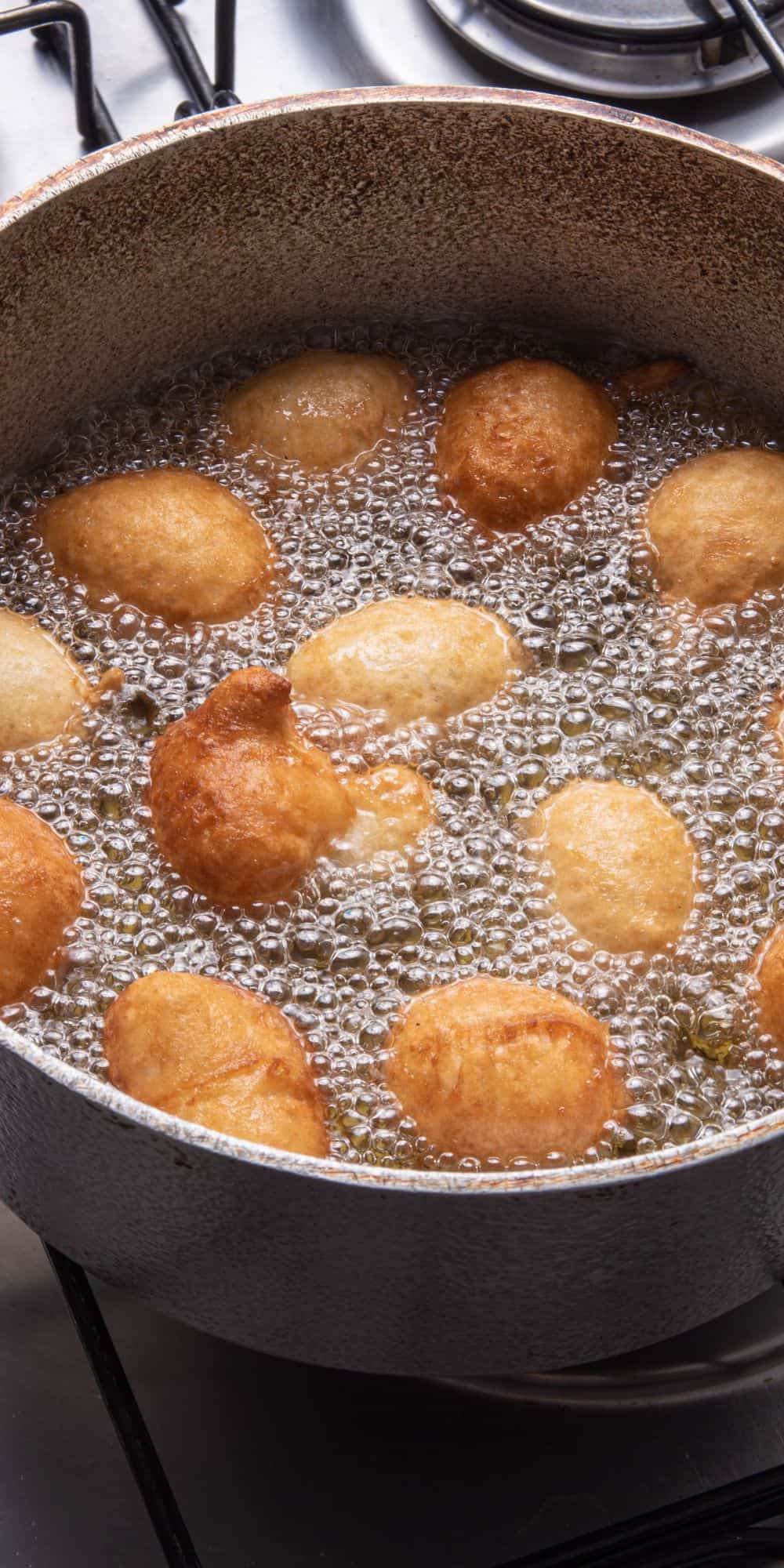 Frying doughnut holes in a pan.