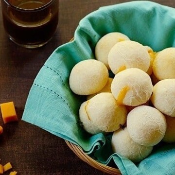 A basket of cheese rolls lined with a sea green cloth