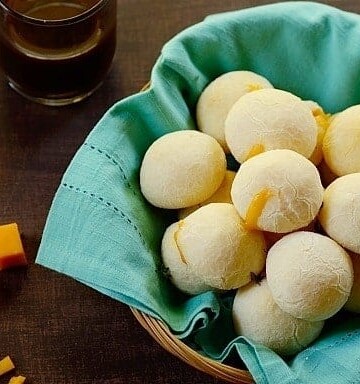 A basket of cheese rolls lined with a sea green cloth