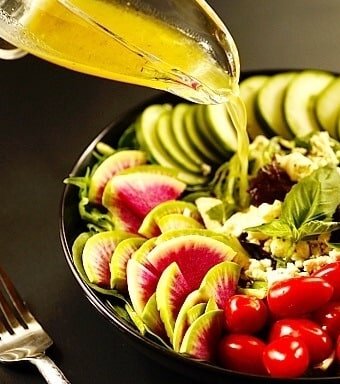 A  plate of salad with vinaigrette dressing