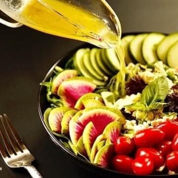 A  plate of salad with vinaigrette dressing