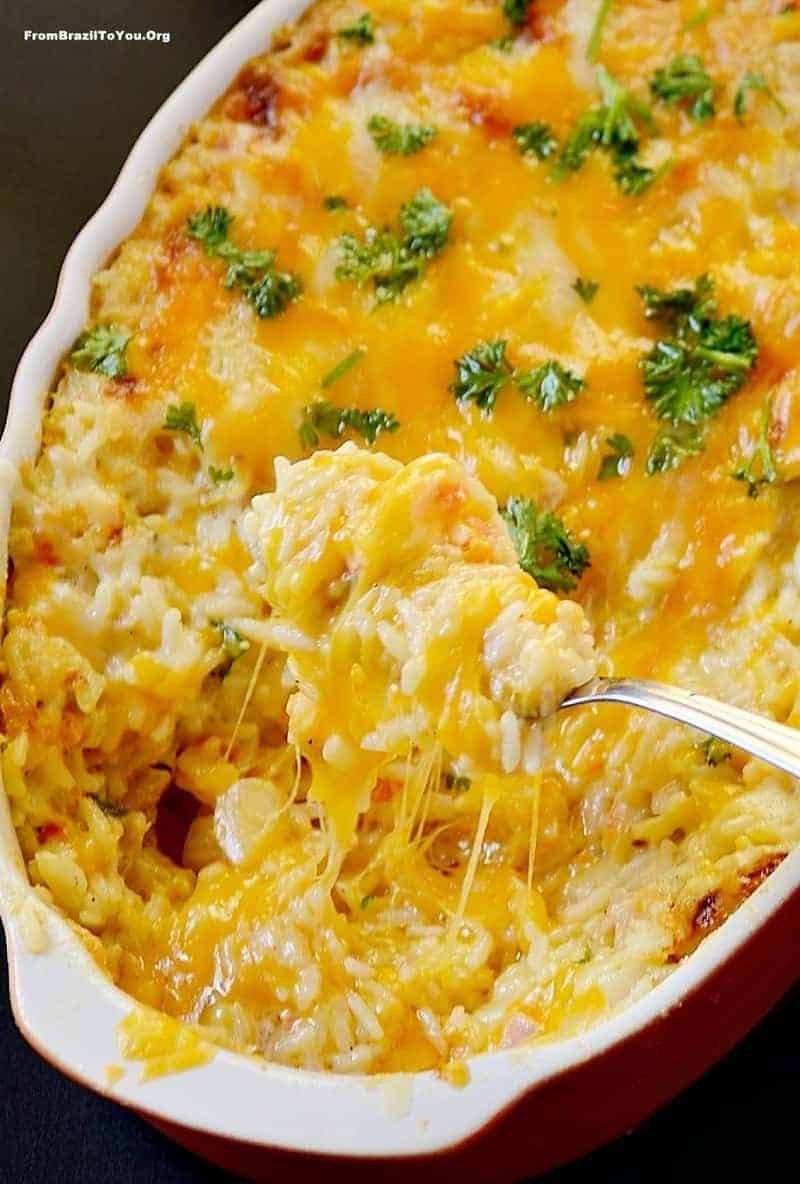 A close up of a dish of cheesy rice casserole with broccoli