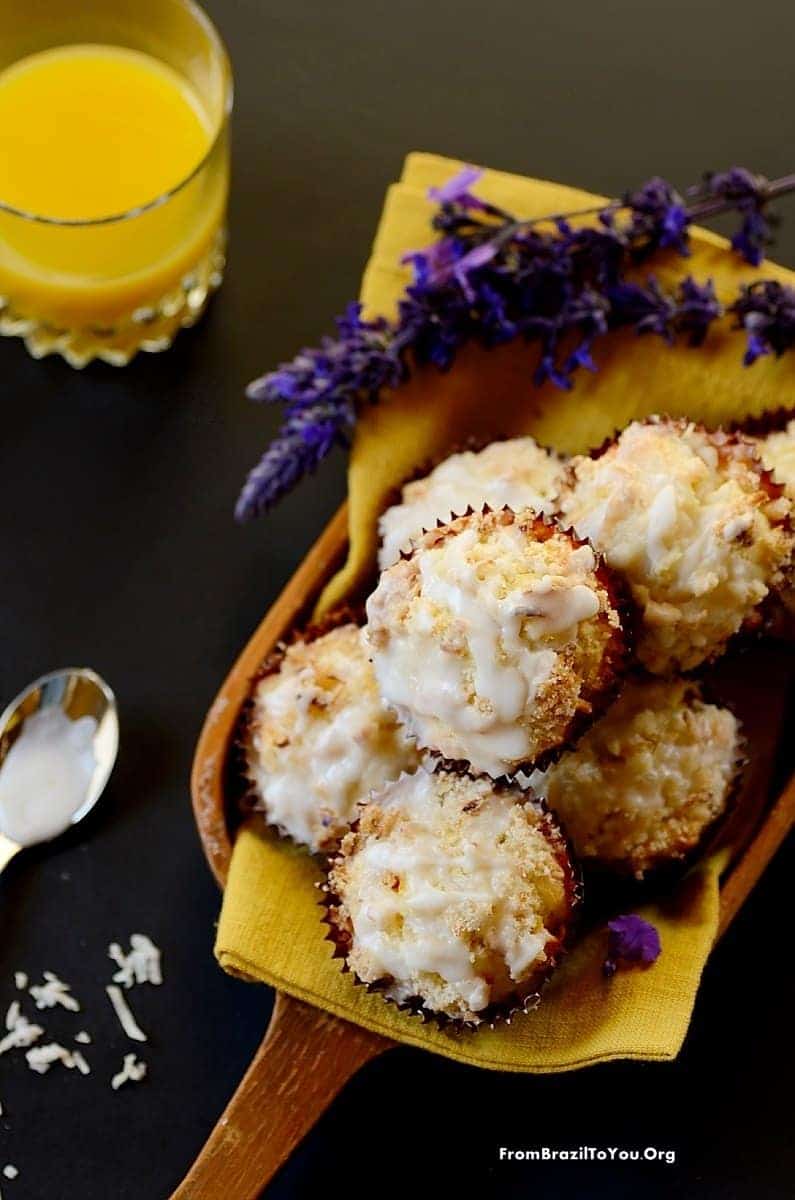 Serving Mango Coconut Streusel Muffins in a platter with flowers on the side and a glass of juice