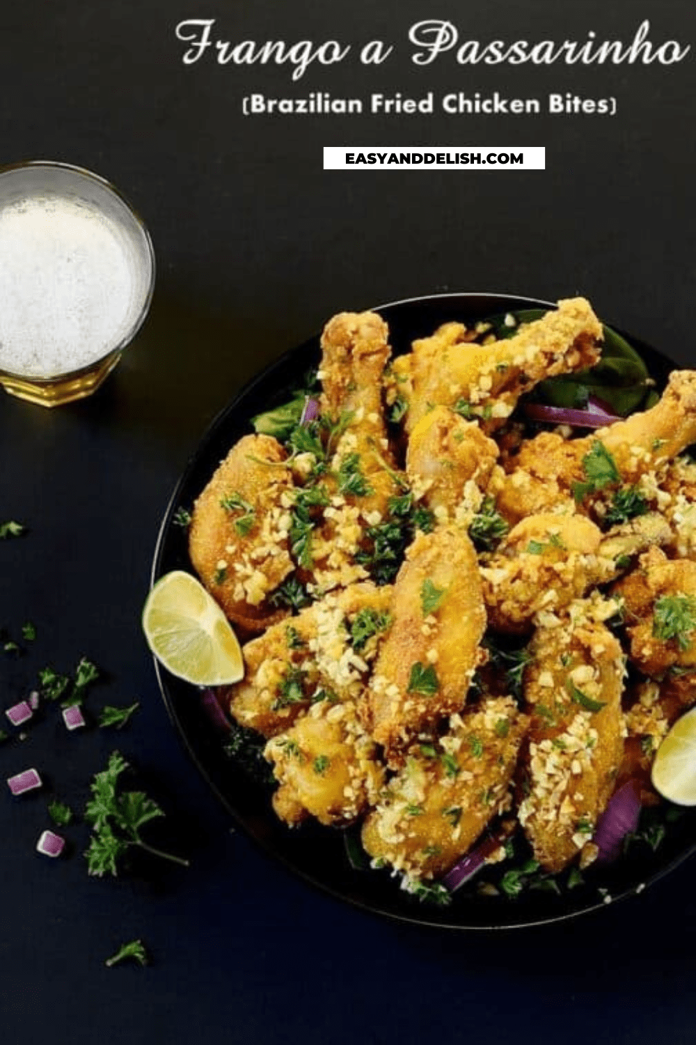 a glass of beer and a plate with fried chicken wings