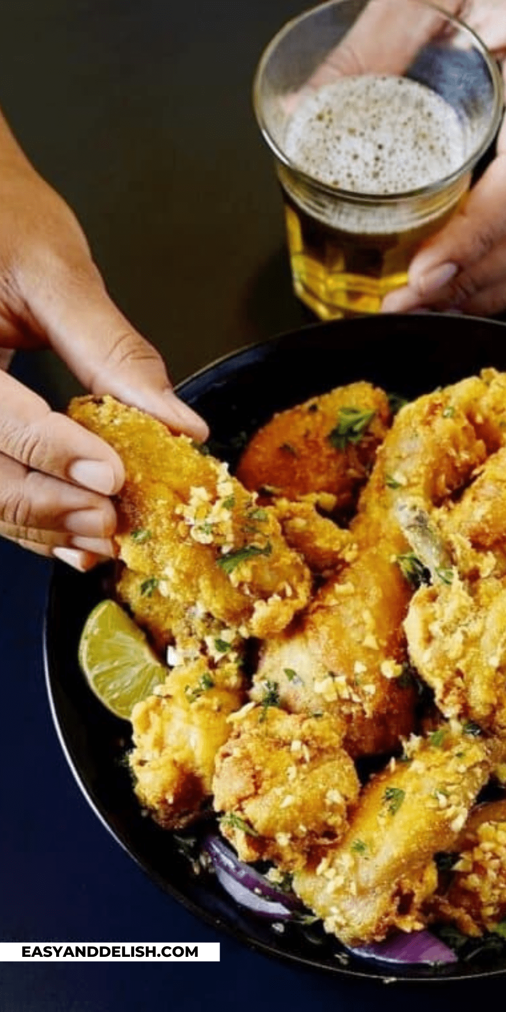 a hand holding fried chicken bites