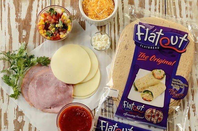 Ham, cheeses, and flatbread on a wooden board