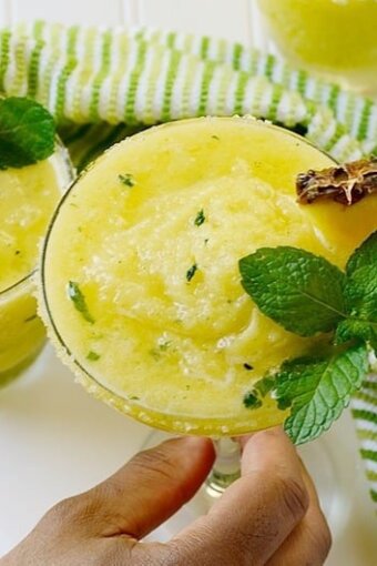Pineapple margarita topped with mint leaves