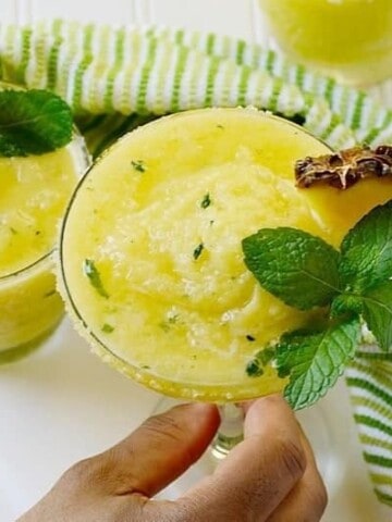 Pineapple margarita topped with mint leaves