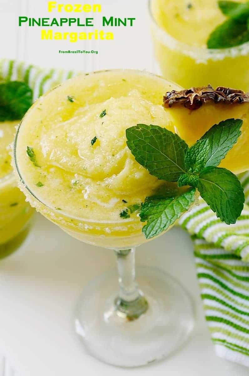pineapple cocktail in a glass topped with mint leaves