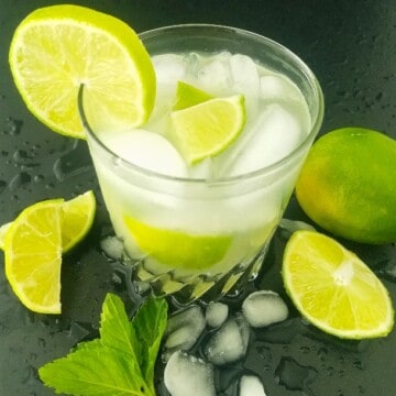 um copo de caipirinha com limão ao lado