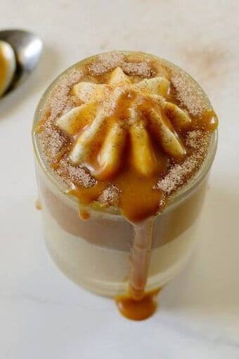 dulce de leche dessert in a glass cup with a spoon beside it