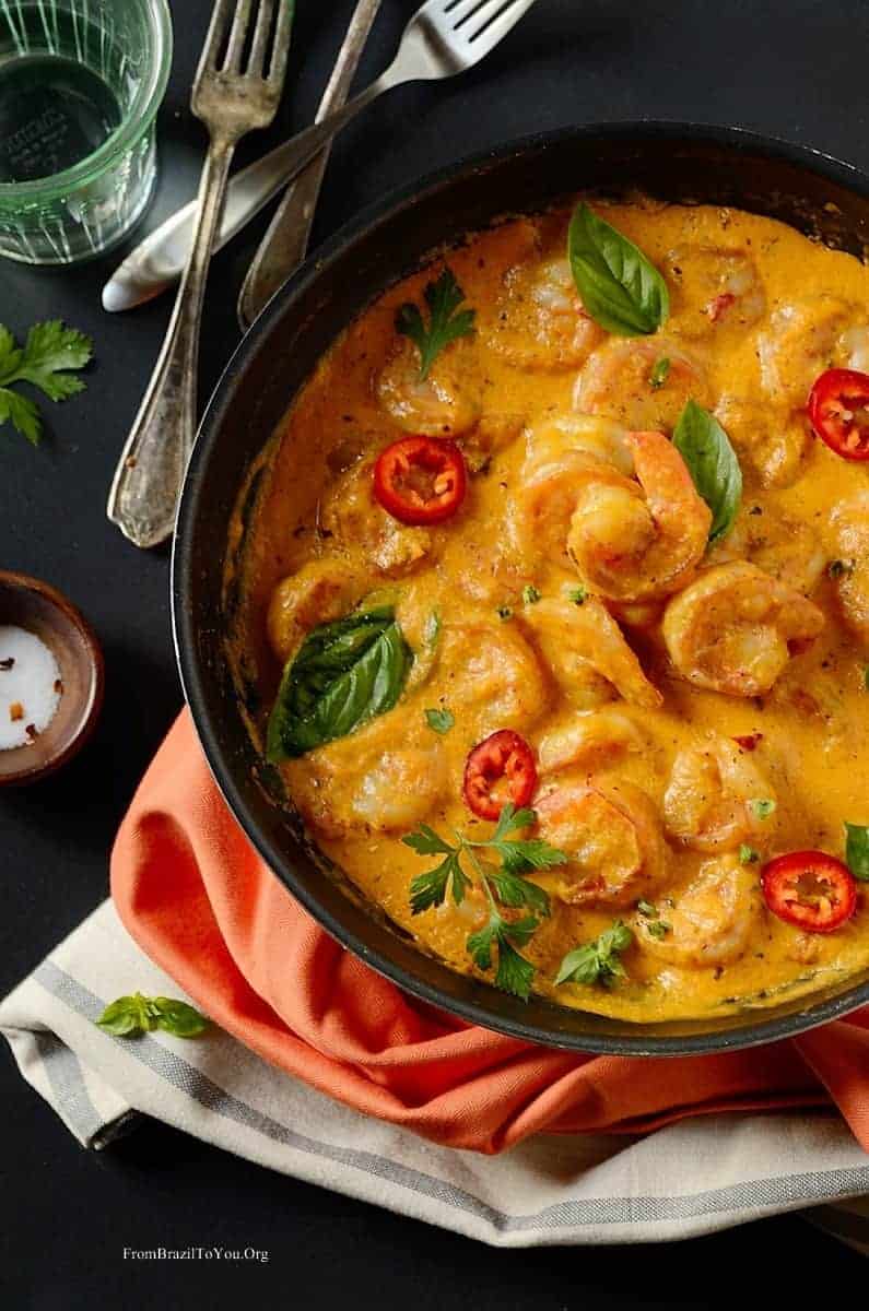 shrimp in coconut sauce in a pan with forks on the side