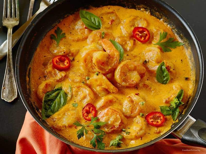 A close up of a bowl of shrimp in sauce