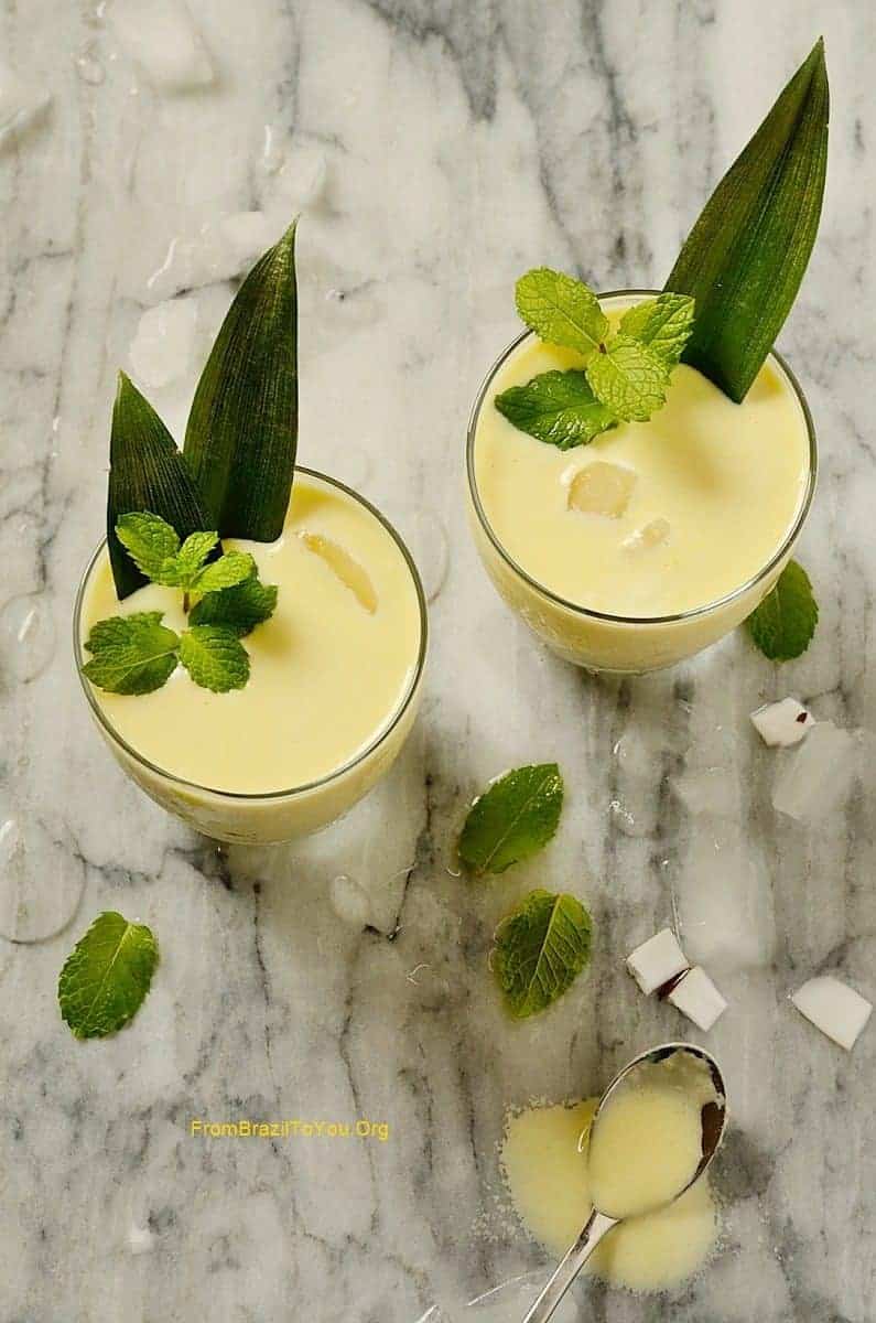 Two glasses of coconut cocktail garnished with mint