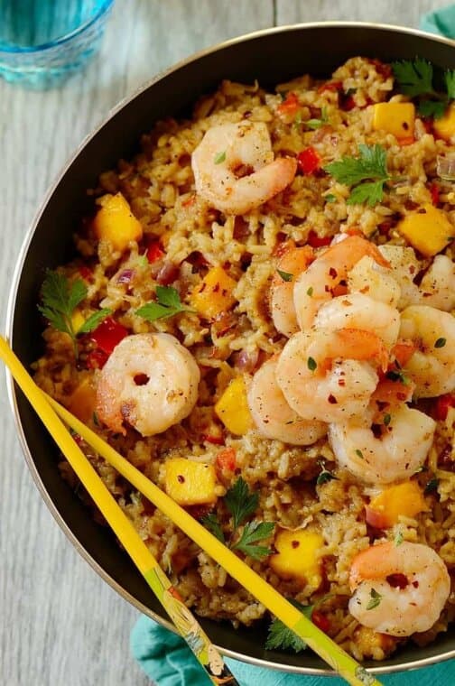 shrimp fried rice in a skillet with chopsticks on the side