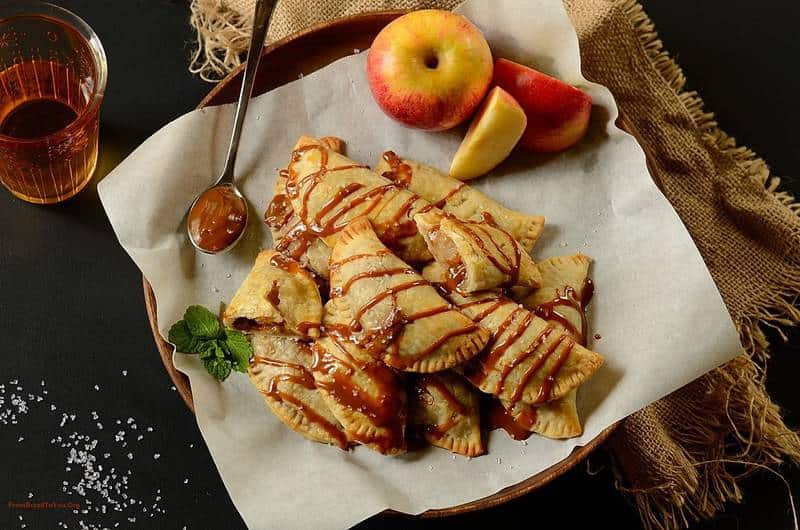 Dulce de Leche Apple Hand Pies in a platter with apple slices on the side