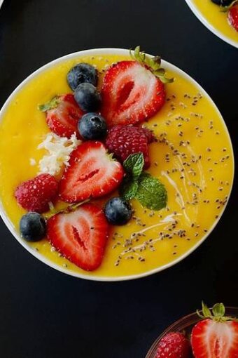 mango smoothie topped with strawberries and chia seeds