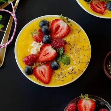 mango smoothie topped with strawberries and chia seeds