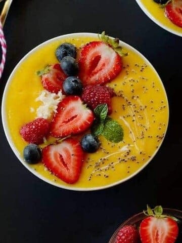 mango smoothie topped with strawberries and chia seeds