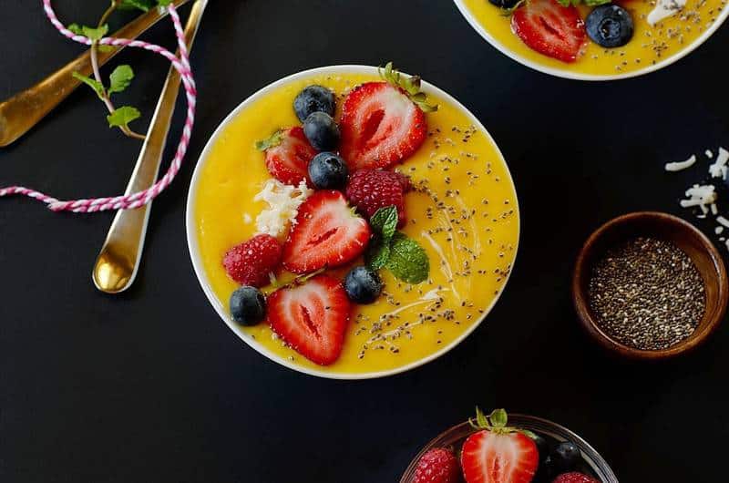 mango smoothie topped with strawberries and chia seeds