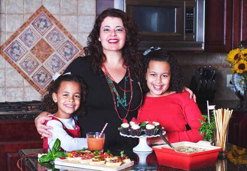 Denise, author of Easy and Delish, with her daughters in the kitchen cooking food.