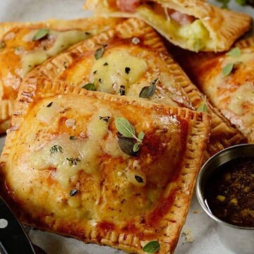 A close up of a plate of food with ham and cheese pastries