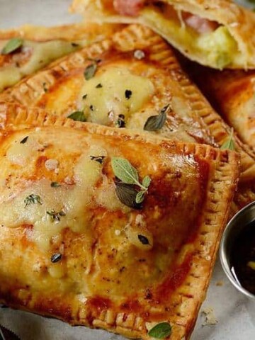 A close up of a plate of food with ham and cheese pastries