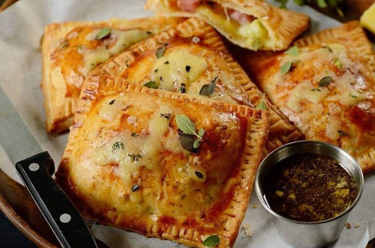 A close up of a plate of food with ham and cheese pastries