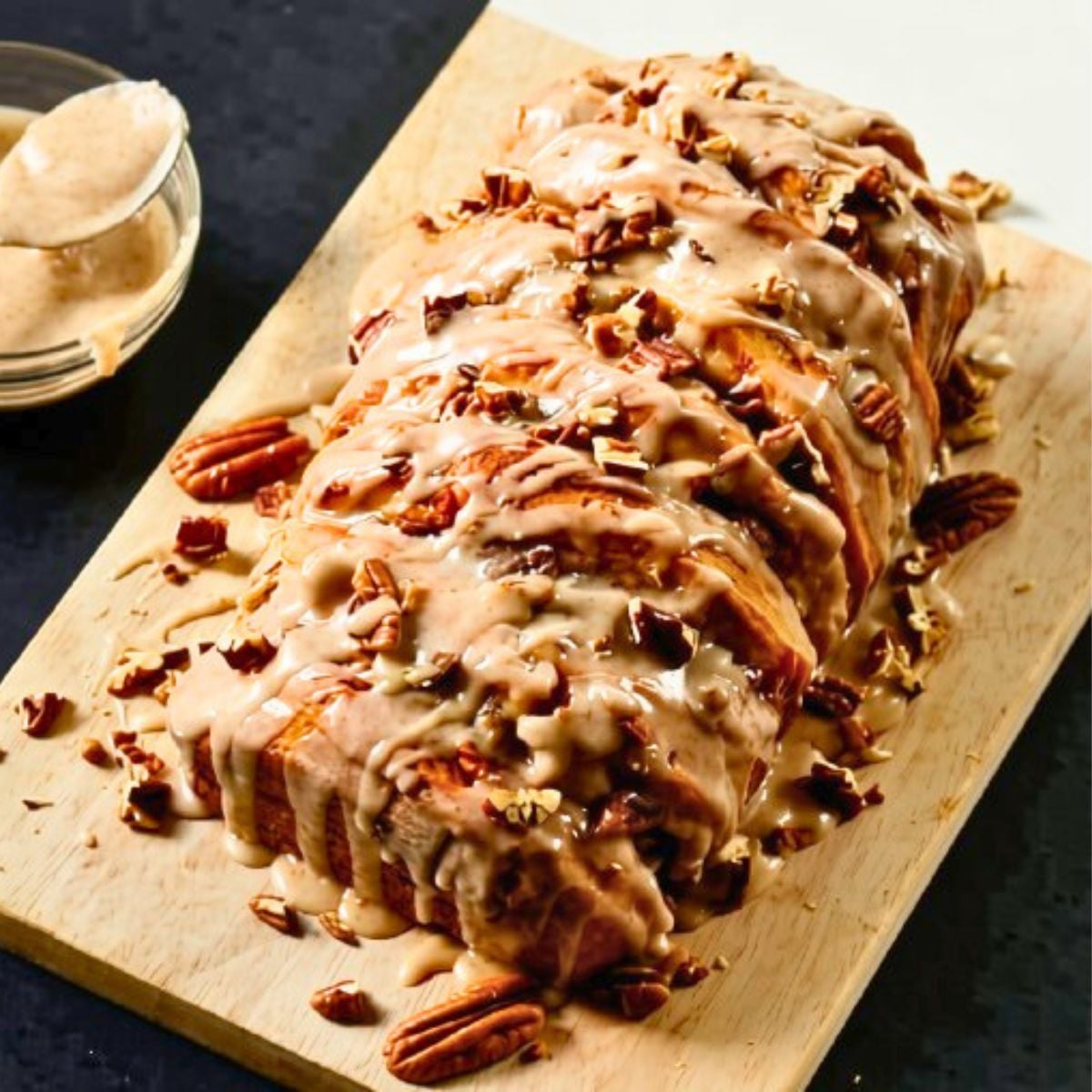 Easy and addictive Pumpkin Pie Spice Pull Apart Bread drizzled with a pumpkin pie spice glaze and topped with chopped pecans. It is to die for! Pumpkin pie spice pull-apart bread with pecans and glaze.