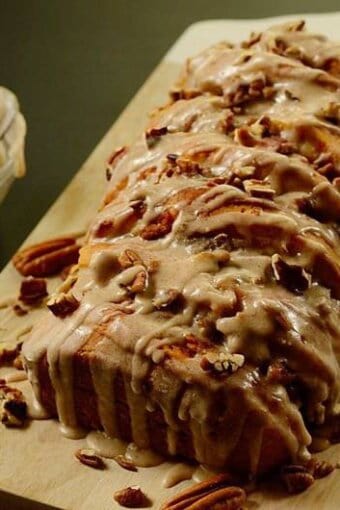 A slice of pumpkin bread on top of a wooden cutting board