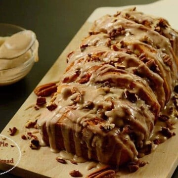 A slice of pumpkin bread on top of a wooden cutting board