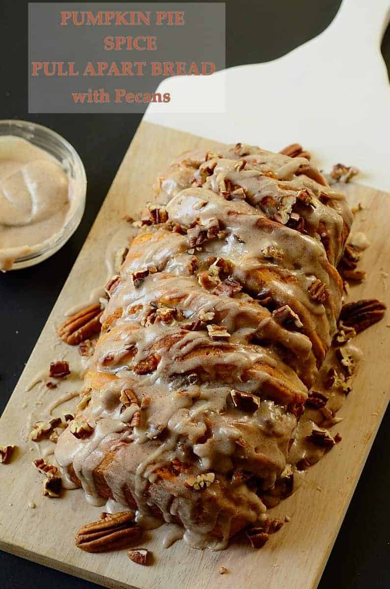 pumpkin spice bread drizzled with glaze and topped with chopped pecans