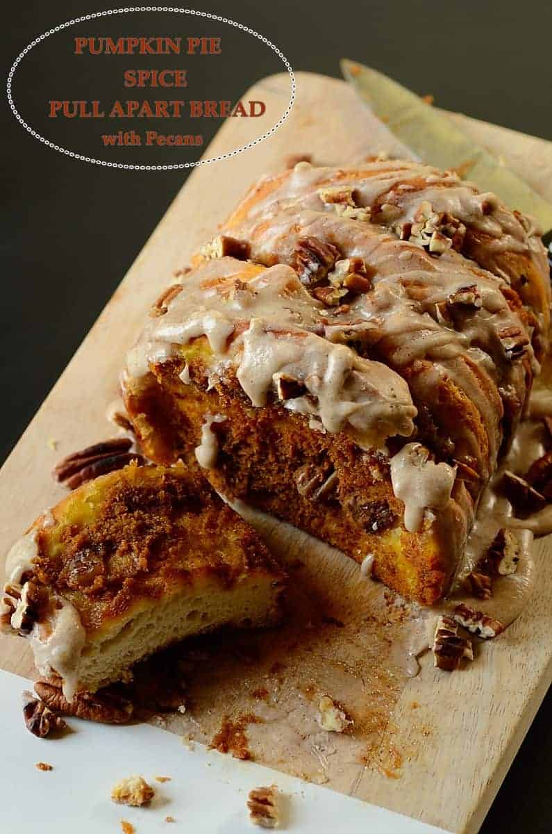 partially sliced pumpkin pull apart bread over a cutting board