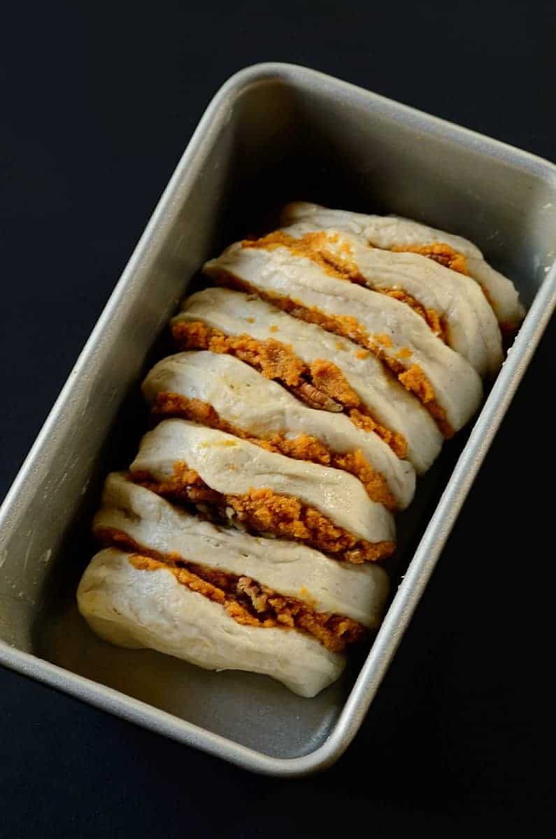 lineing up filled biscuits in a bread pan 