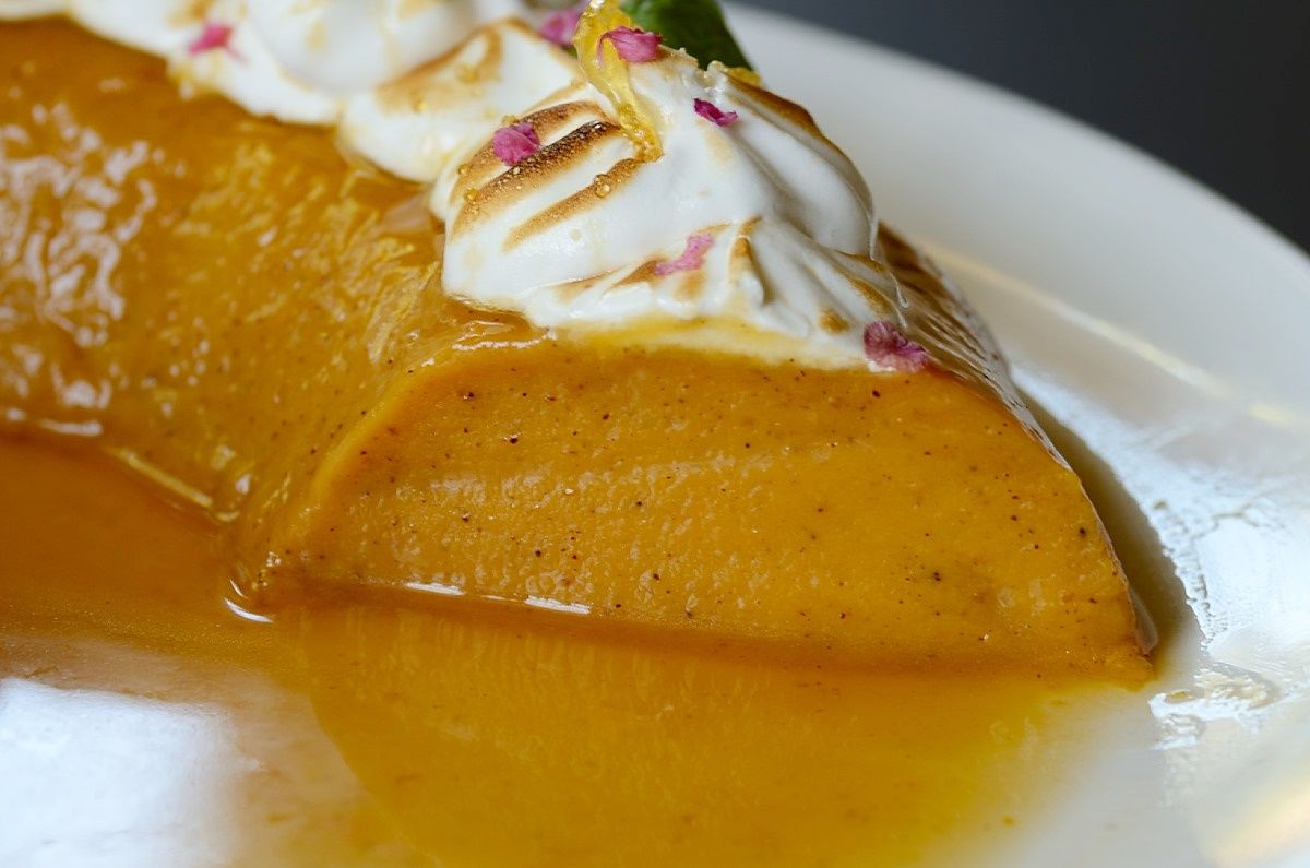 A close up of a slice of sweet potato flan on a plate