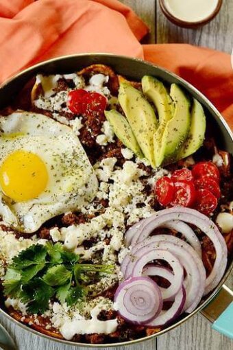 A bowl of breakfast chilaquiles on a table.